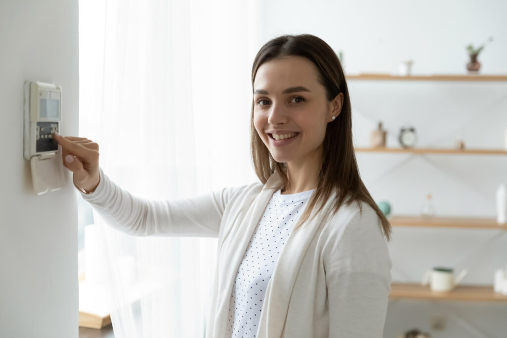 Glückliche Kundin bedient Heizthermostat